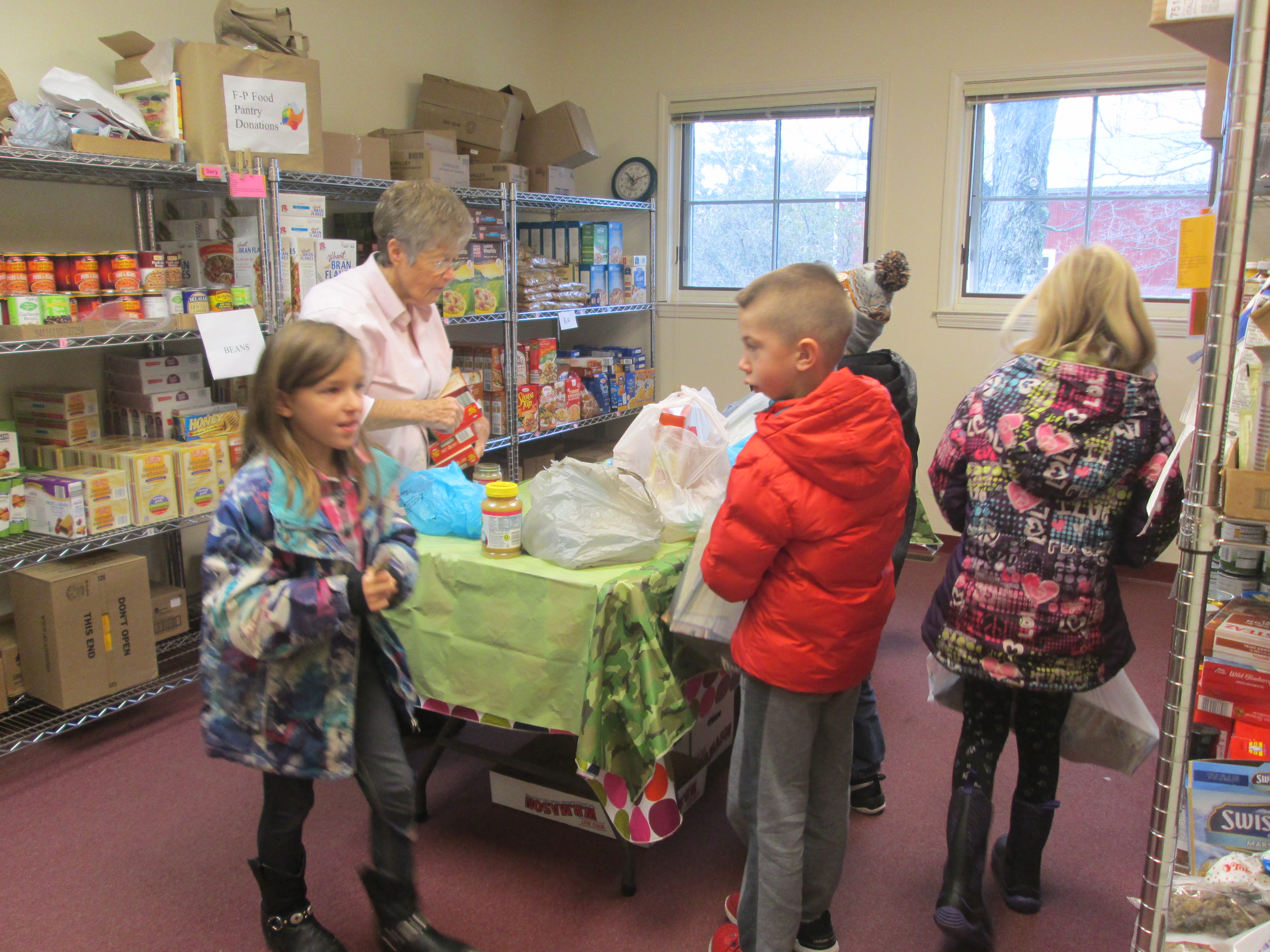 students delivering food to pantry